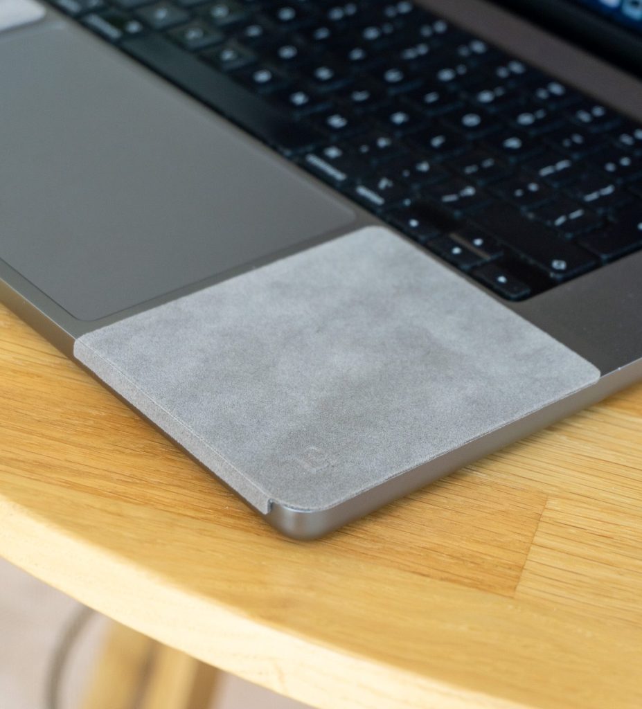 ChronoPad palm rest protector fitted to a space grey MacBook on a wooden desk